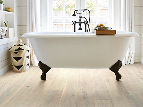 White bathtub in a bathroom with wood-look luxury vinyl flooring from Value Flooring Kitchens & Baths in Cleveland, TN